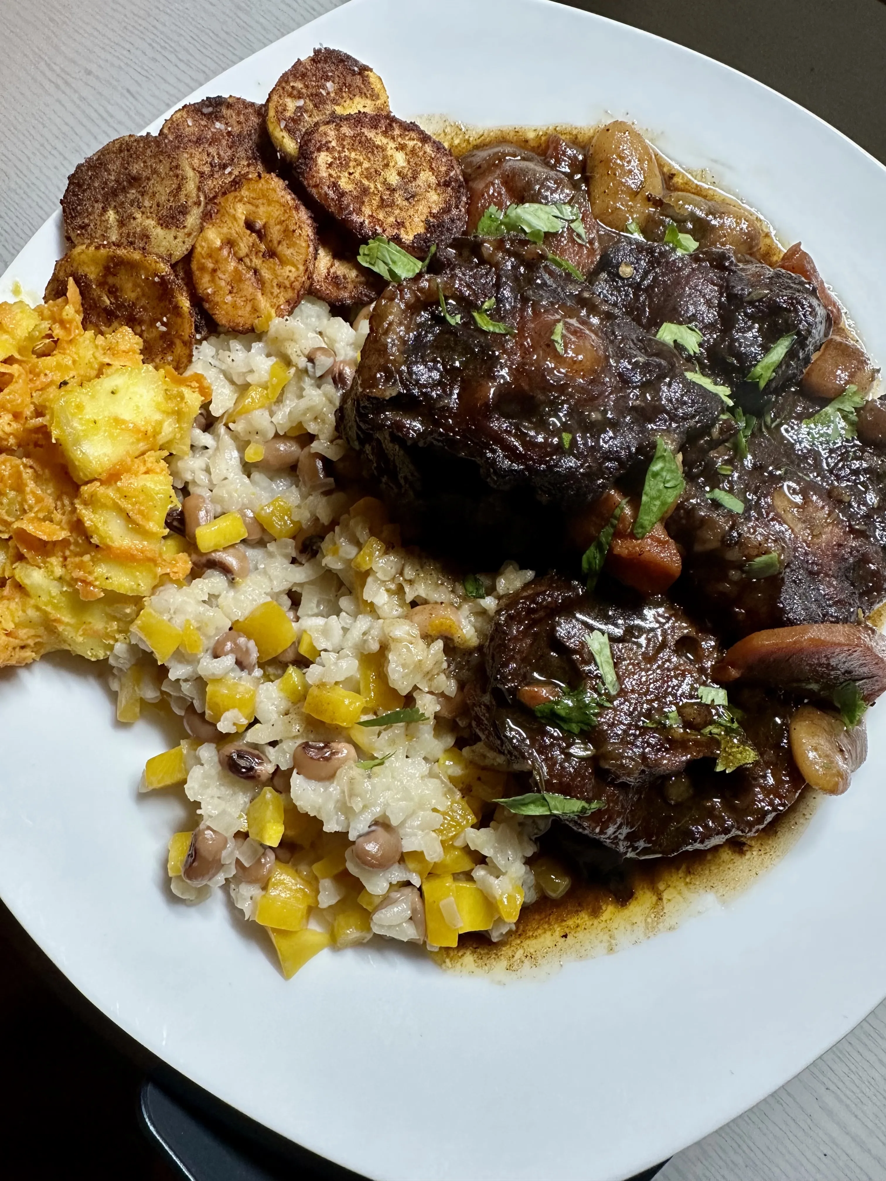 Jamaican Oxtail Stew, Fried Plantains, Black Eyed Peas Rice, and Cassava Salad
